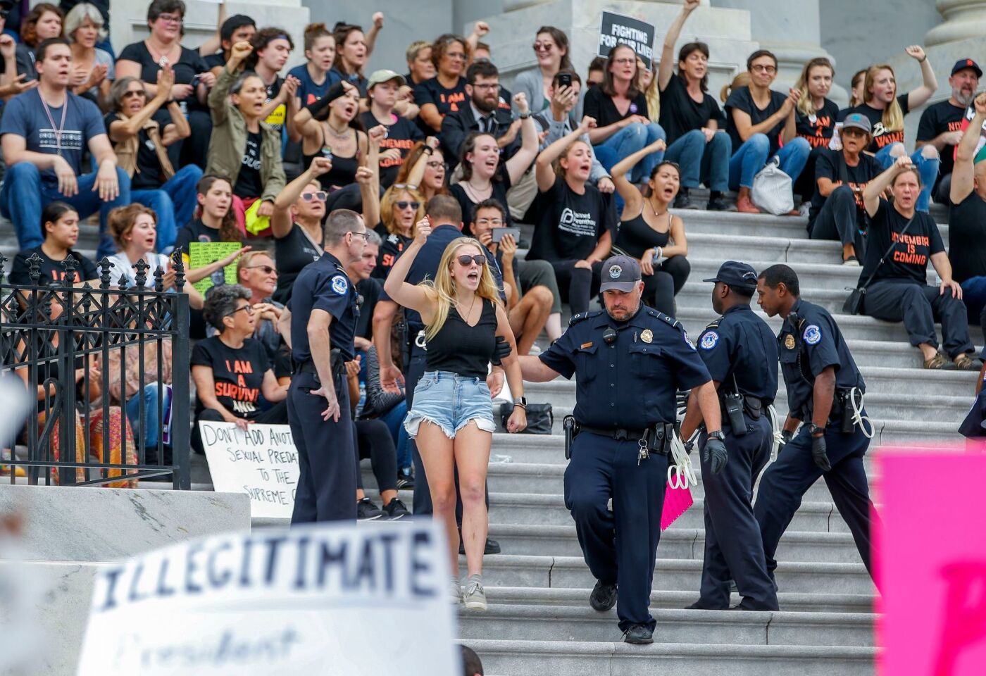 Police detain protesters who occupied the East Front steps of the U.S. Capitol before the Senate voted on the confirmation of Brett Kavanaugh.