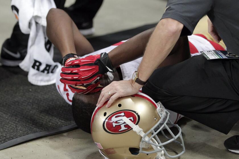 San Francisco running back Reggie Bush is tended to by a trainer after he slipped out of bounds against the St. Louis Rams on Nov. 1.