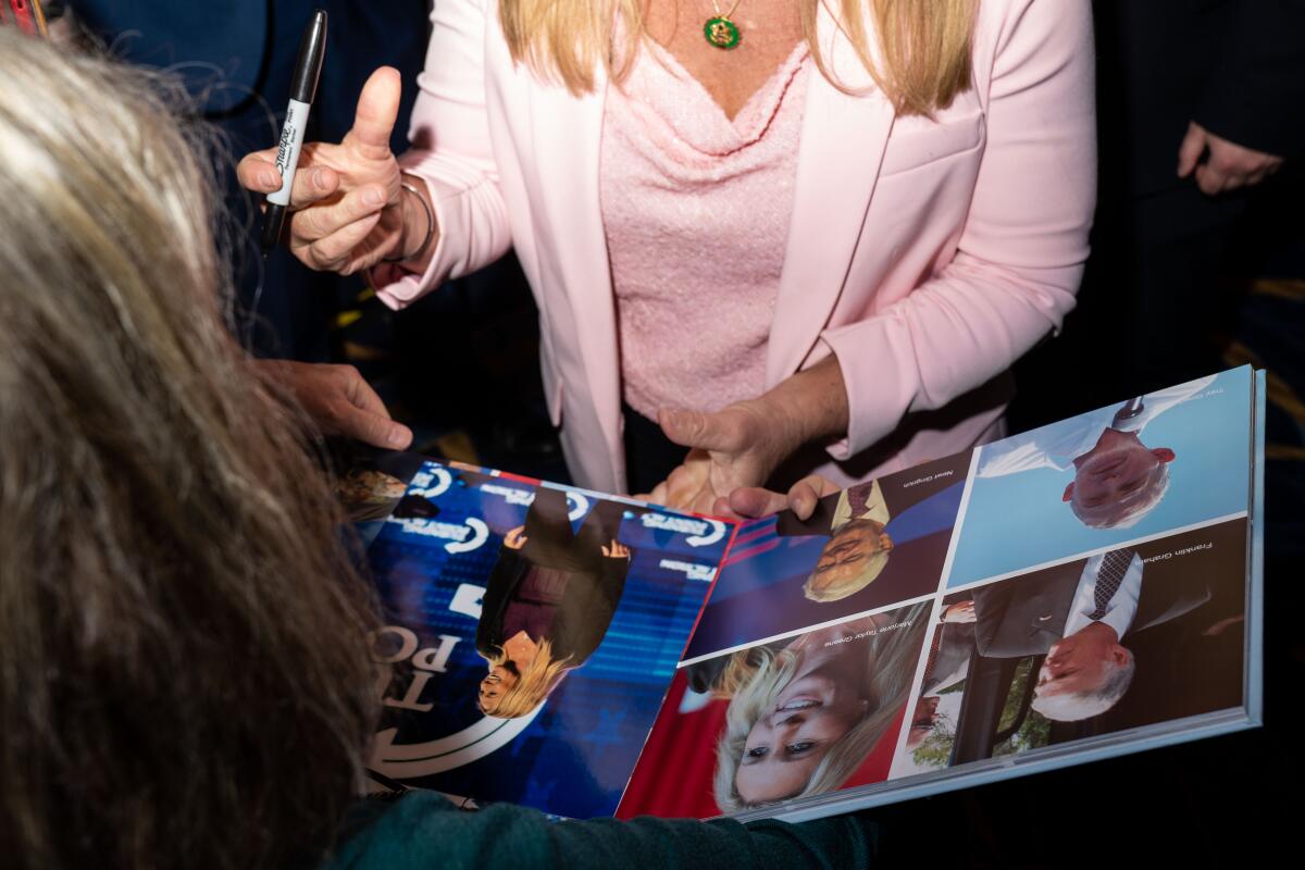 Rep. Marjorie Taylor Greene (R-Ga.) signs autographs at CPAC