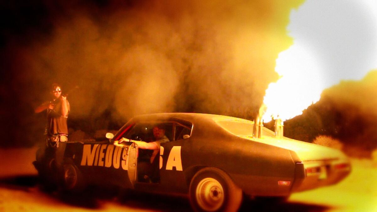 A car spits flames into the night sky in the film "Bellflower."