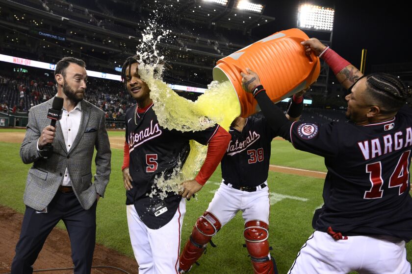 Washington Nationals' CJ Abrams (5) gets doused by Ildemaro Vargas (14) and Tres Barrera (38) after the team's baseball game against the Atlanta Braves, Wednesday, Sept. 28, 2022, in Washington. Abrams hit a single to score Alex Call with the winning run. The Nationals won 3-2 in 10 innings. (AP Photo/Nick Wass)