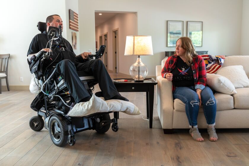 Kenton Stacy, a Navy bomb technician left paralyzed by an IED in Syria in 2017, along with his wife, Lindsey, check out their new specially built home from the Gary Sinise Foundation after the dedication ceremony on Friday. N photo by Don Boomer