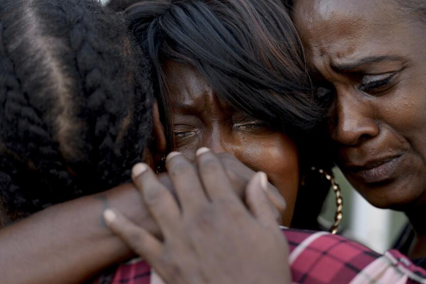 Alice Corley, the mother of Lionel V. Gibson Jr.; Tritoba Ford, the mother of Ezell Ford; and Pamela Fields the mother of Dante Jordan, embrace at a protest outside the office of Dist. Atty. Jackie Lacey.