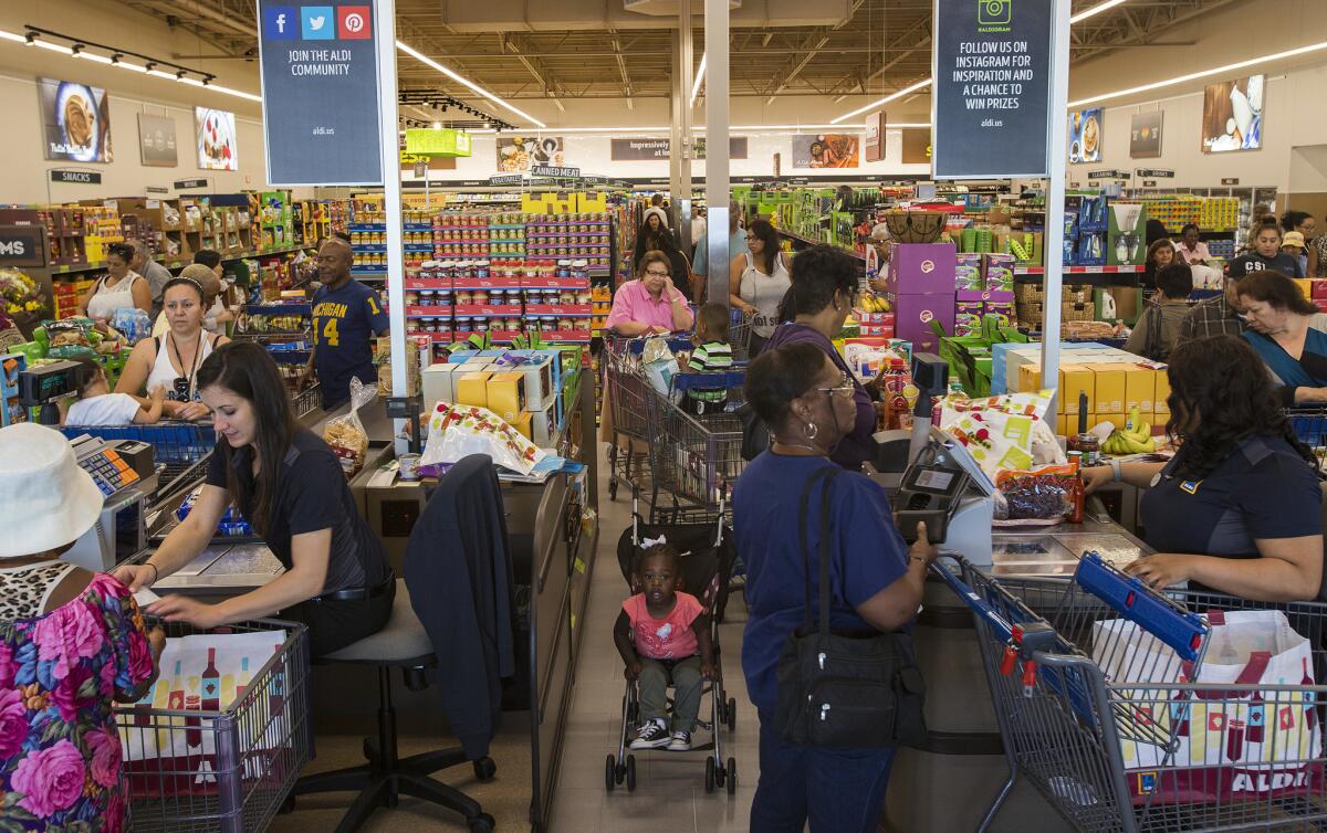 Shoppers wait in crowded lines to purchase groceries at the grand opening of Aldi on April 21 in Inglewood