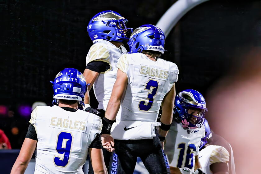 Quarterback Fletch Palmer (3) of unbeaten Santa Margarita gives chest bump to Grant Mosley.