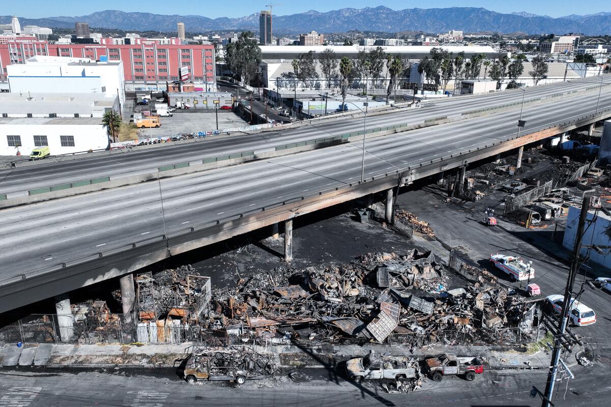 Aerial views of the 10 Freeway on Sunday after a large pallet fire burned below, shutting the freeway to traffic.