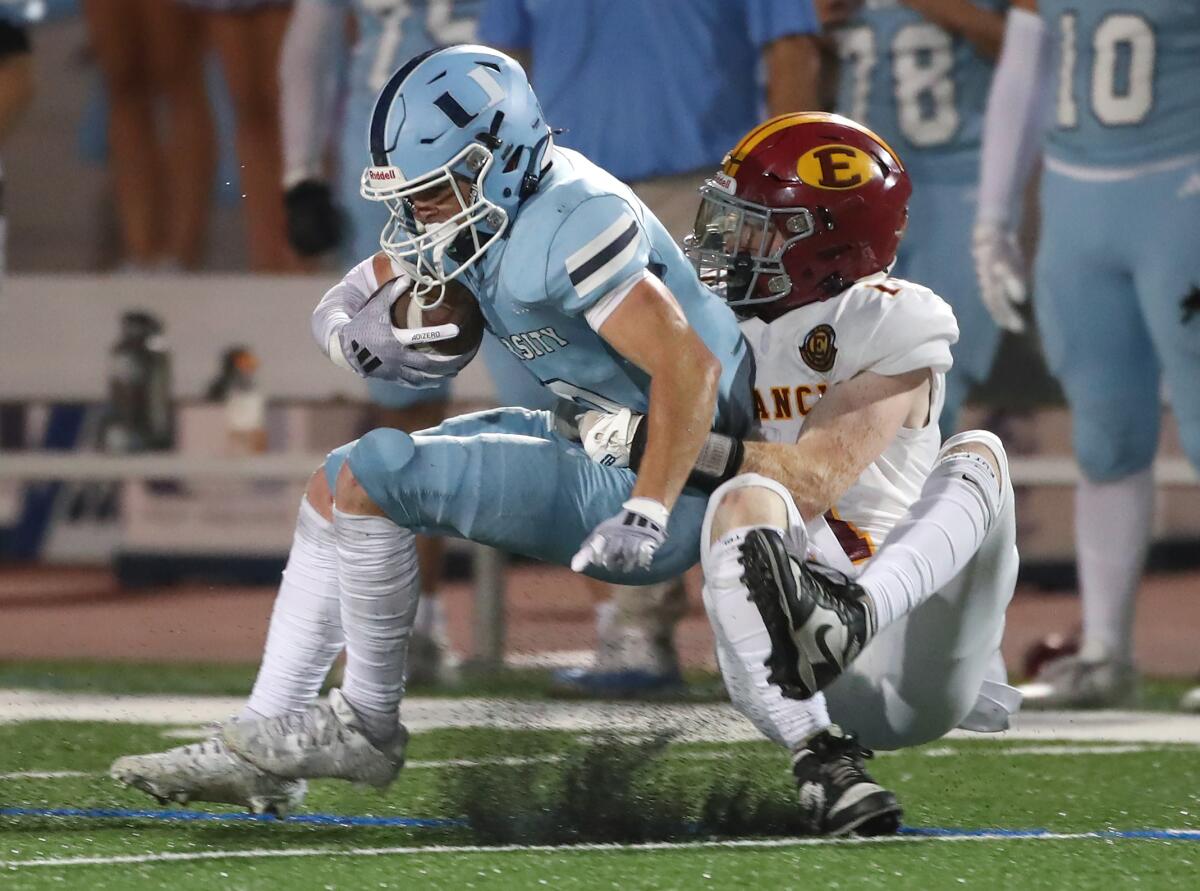 Estancia's Sean Sweeney, right, drags down University's Carl Oldham near the line of scrimmage on Thursday.