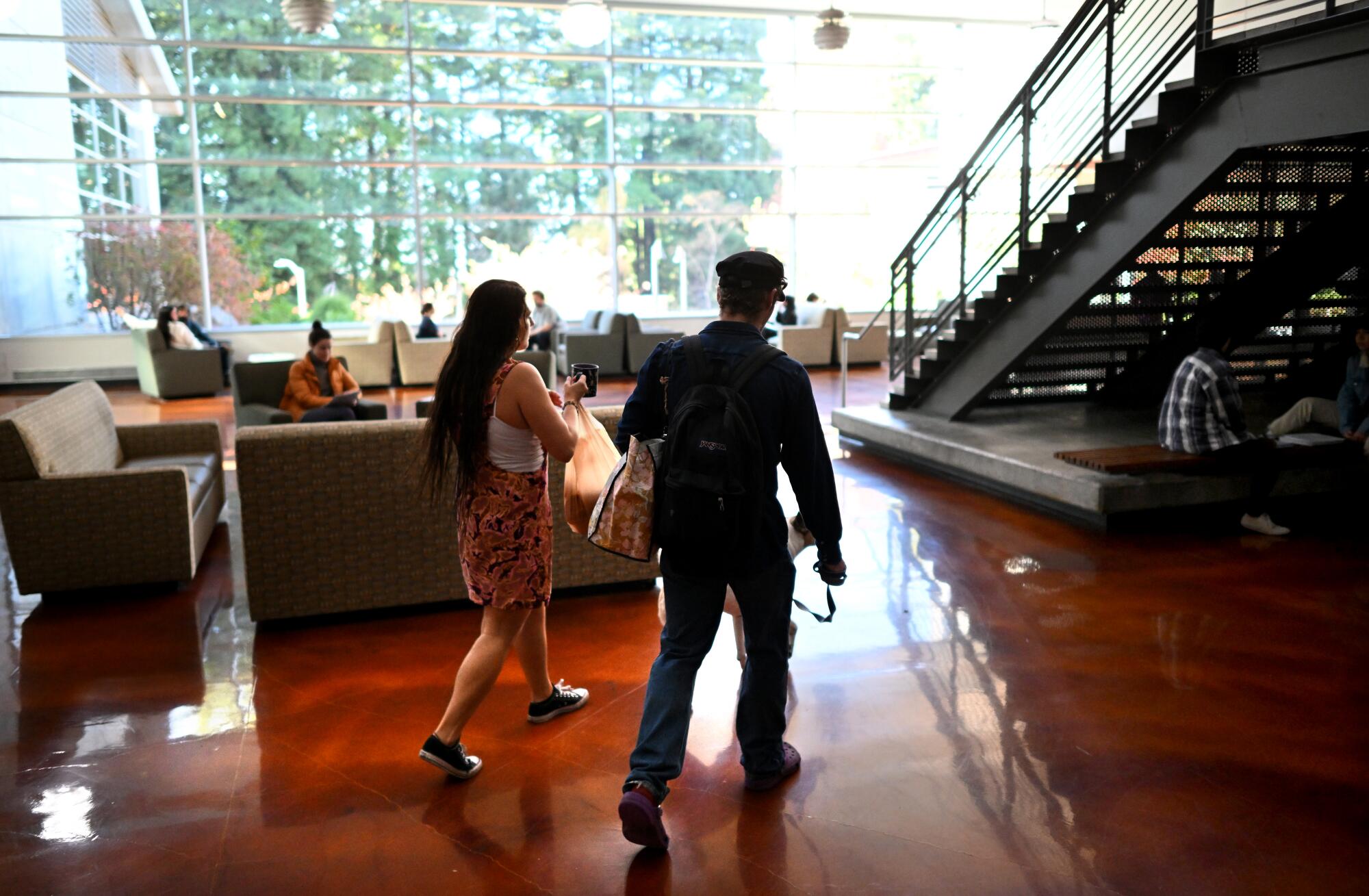 Two people walk through the lobby of a building at Cal Poly Humboldt.