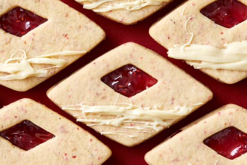 Floral pink peppercorn speckles these delicate Linzer cookie diamonds, sandwiched with raspberry jam and drizzled with creamy white chocolate.