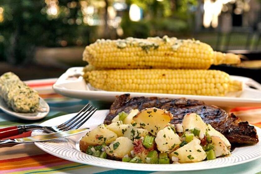 Steak, potato salad with celery and roasted corn.