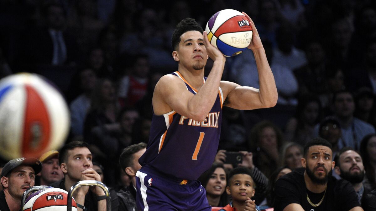 Suns guard Devin Booker puts on a performance during the Three-Point Shooting Contest on Saturday at Staples Center, which JaVale McGee apparently can't believe.