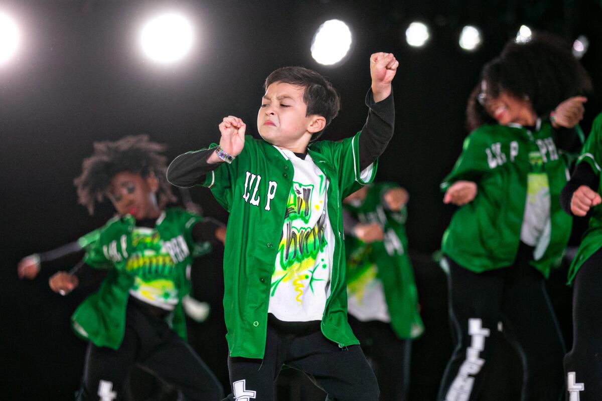 A group of children dancing in green Lil Phunk jackets.