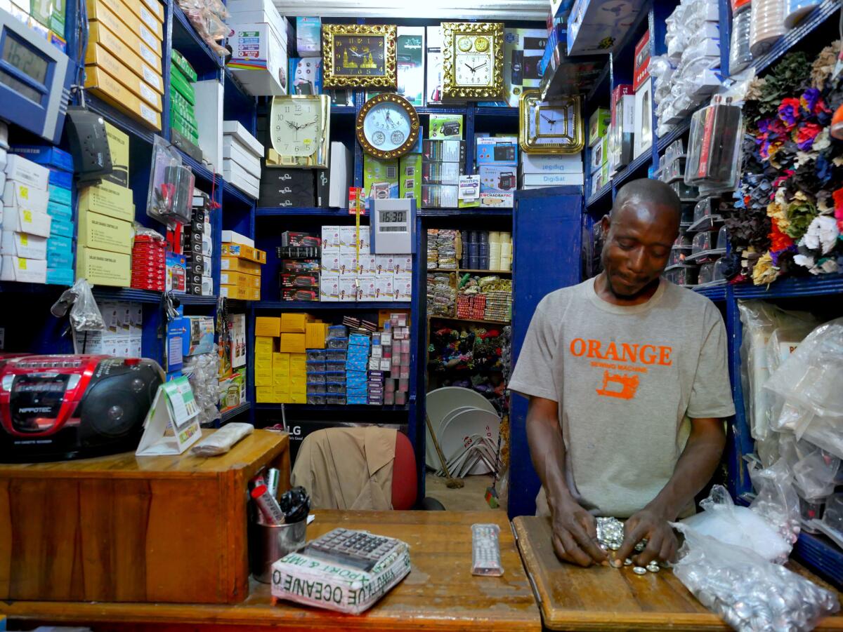 A worker counts buttons at Adama Keita’s shop at the Dabanani market in Bamako, Mali, in March. Most Malians, who can’t read or write, find the web of little use, but Lenali, a phone-to-web app, is drawing users.