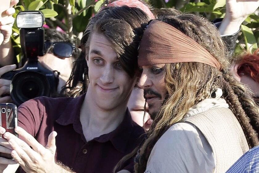 Hollywood actor Johnny Depp (C), dressed as Captain Jack Sparrow from the Pirates of the Caribbean film franchise, poses for a "selfie" with a fan after returning from a day on the film set, in Redland Bay, some 35 kms southeast of Brisbane on June 4, 2015. Depp has been in Queensland state to film the Disney movie "Pirates of the Caribbean: Dead Men Tell No Tales", the fifth installment in the blockbuster series, which has raked in more than 3.6 billion USD at the box office. AFP PHOTO / Tertius PICKARD (Photo credit should read TERTIUS PICKARD/AFP/Getty Images) ** OUTS - ELSENT, FPG, CM - OUTS * NM, PH, VA if sourced by CT, LA or MoD **