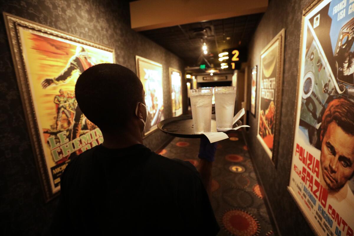 A man in a corridor lined with movie posters