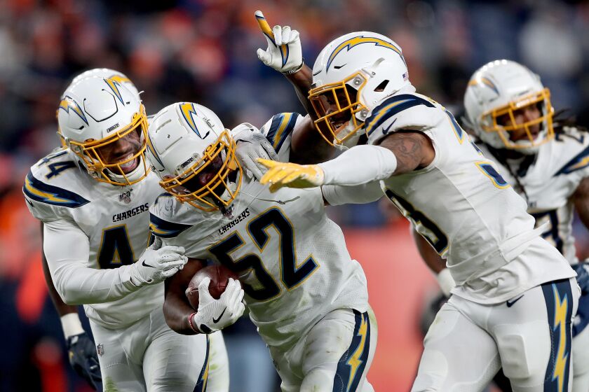DENVER, COLORADO - DECEMBER 01: Denzel Perryman #52 of the Los Angeles Chargers celebrates with Kyzir White #44 and Derwin James #33 after making an interception against the Denver Broncos in the fourth quarter at Empower Field at Mile High on December 01, 2019 in Denver, Colorado. (Photo by Matthew Stockman/Getty Images)