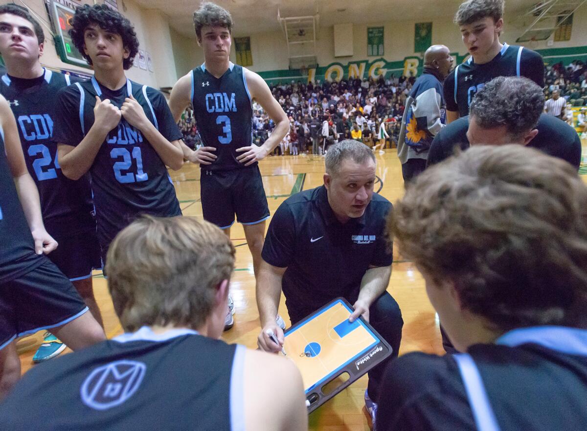 Corona del Mar boys' basketball coach Jason Simco addresses his team during a timeout Friday night. 