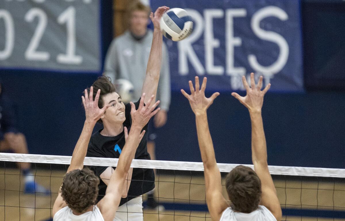 Corona del Mar's Luke Chandler hits against Newport Harbor's Brendan Read, left, and James Eadie on Tuesday.