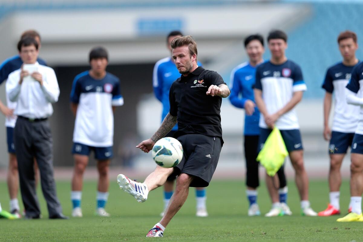 David Beckham, shown during a training session with Jiangsu Sainty players at Nanjing Olympic Sports Center in China on Tuesday, was reportedly invited to try out for the NFL.