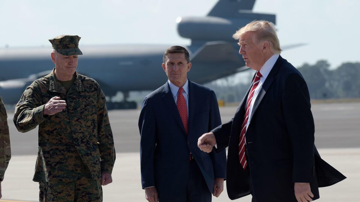 President Donald Trump passes Joint Chiefs Chairman Gen. Joseph Dunford, left, and then-National Security Adviser Michael Flynn at MacDill Air Force Base in Tampa, Fla. on Feb. 6.