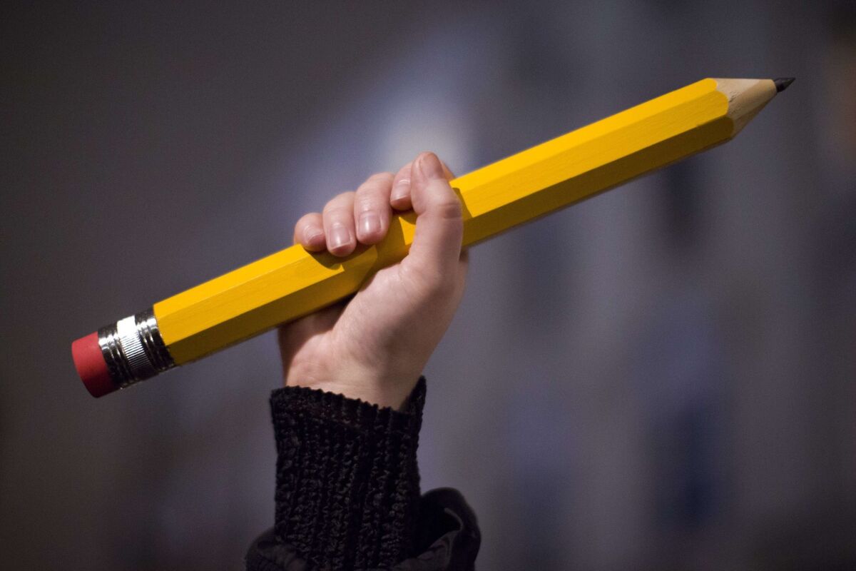 A giant pencil is held at a vigil outside the French Institute in London on Jan. 9 for the 12 victims of the attack on the Paris offices of Charlie Hebdo.