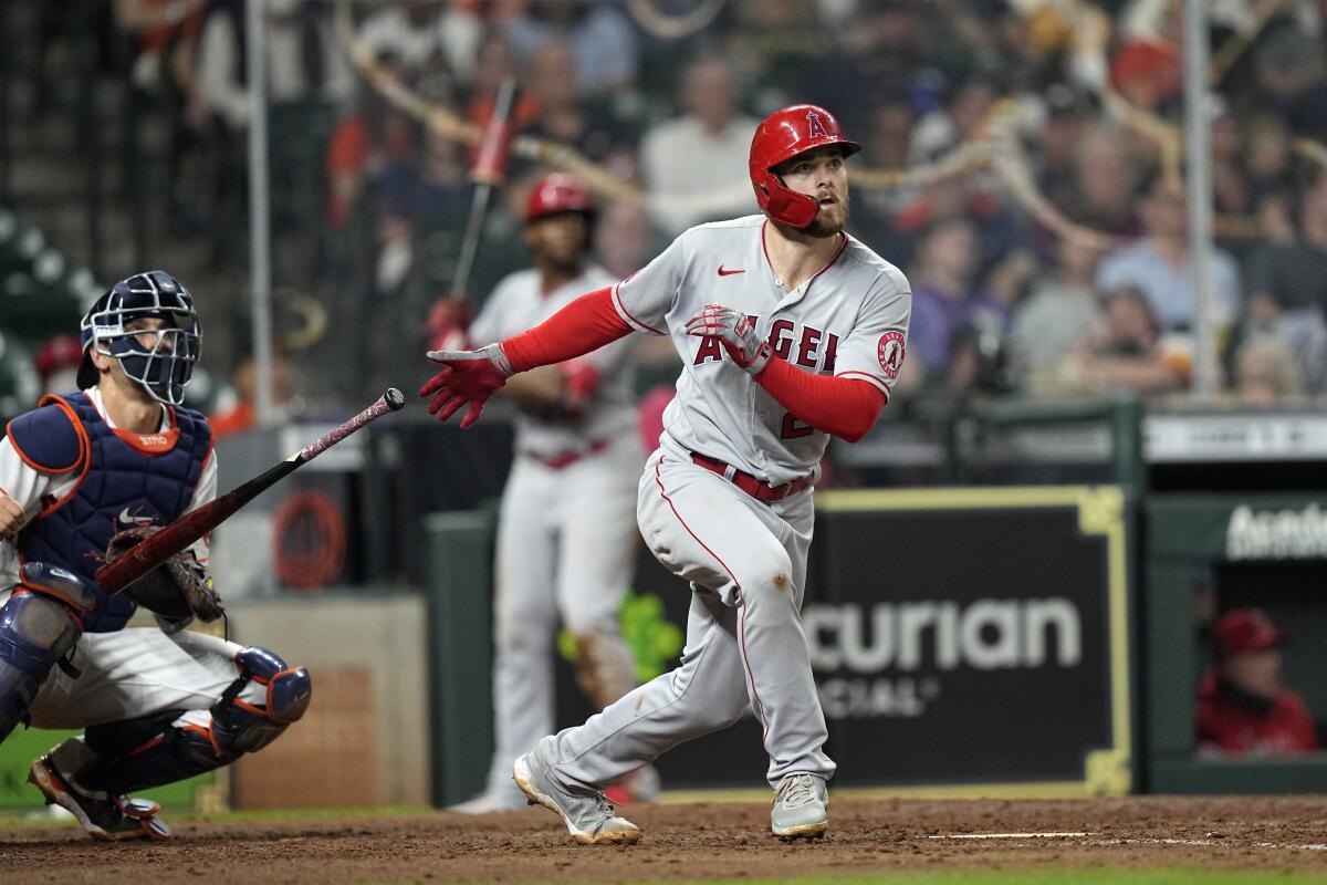 Angels' Jared Walsh hits a home run as Houston Astros catcher Jason Castro watches.