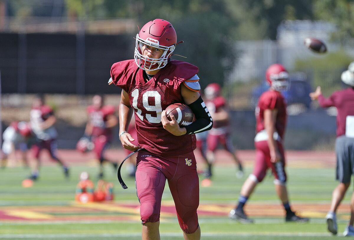 Receiver Justin Zoltzman turns with the ball after making a catch at preseason football practice at La Canada High School on Thursday, August 8, 2019.