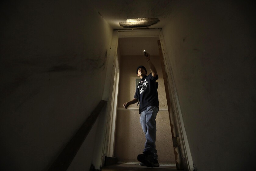 LOS ANGELES, CA - JUNE 21, 2022 - - Maury Bryan Samano, 27, looks at damage caused to his home by the LAPD fireworks explosion in 2021 in Los Angeles on June 21, 2022. Samano and his family return to the place several times a week to make sure looters haven't stolen their belongings. The duplex, where Samano lived with his family, was yellow tagged after the explosion. His family have been living at the Level Hotel for the past year. Many families are still living in the Level hotel a year after the LAPD fireworks explosion destroyed or damaged their homes in Los Angeles. (Genaro Molina / Los Angeles Times)