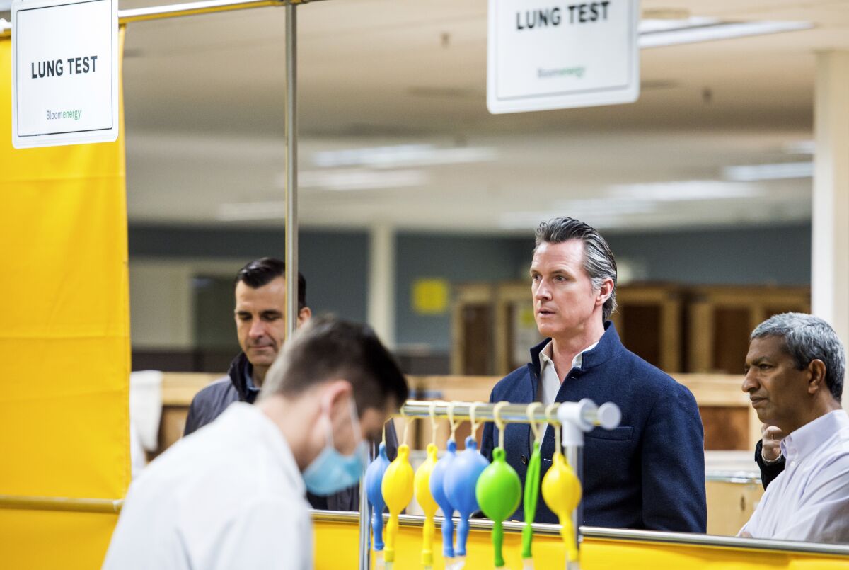 California Gov. Gavin Newsom, second from right, tours the Bloom Energy Sunnyvale, Calif., campus Saturday. Bloom Energy is a fuel cell generator company that has switched to refurbishing ventilators.