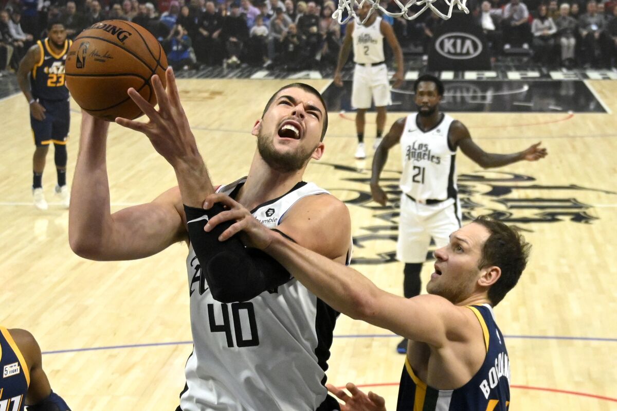 Clippers center Ivica Zubac is fouled by Jazz forward Bojan Bogdanovic during the first half of a game Dec. 28, 2019, at Staples Center.