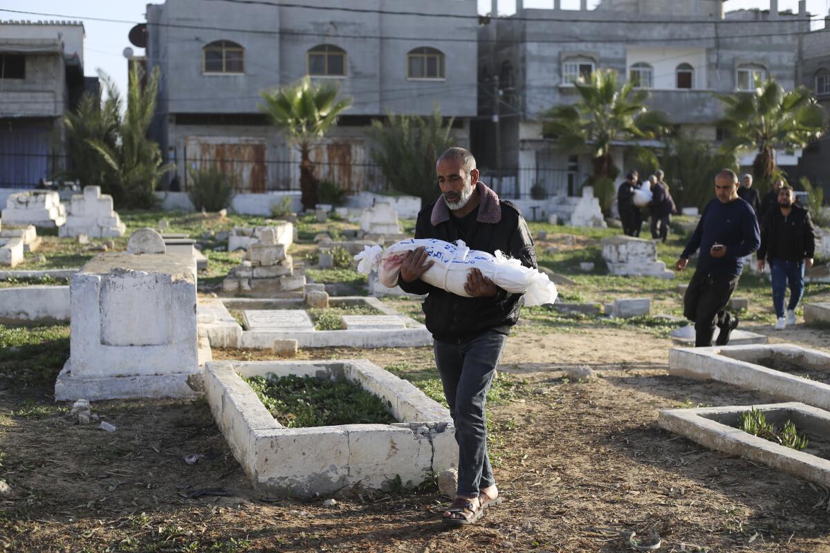 Palestinians carry bodies through a cemetery during a funeral in Rafah, Gaza Strip.