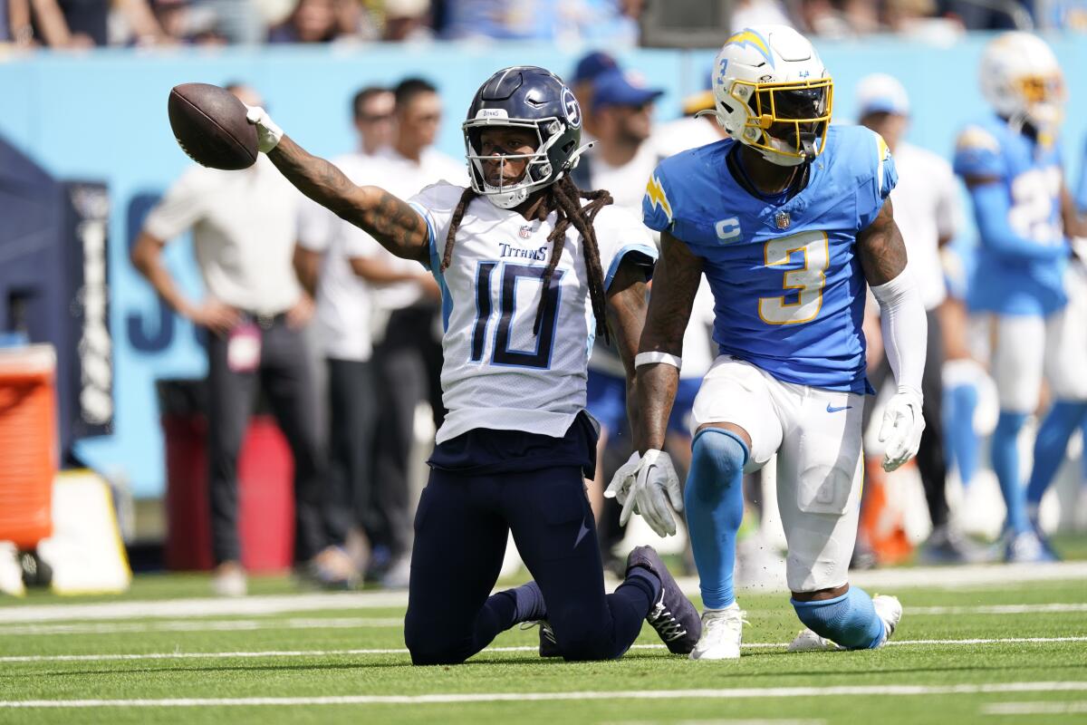 Titans receiver DeAndre Hopkins signals first down after catching a pass next to  Chargers safety Derwin James Jr.