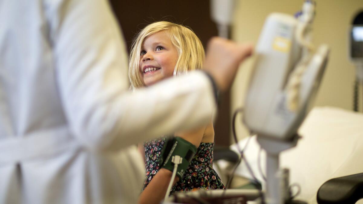 A young girl has her blood pressure measured during a physical exam.