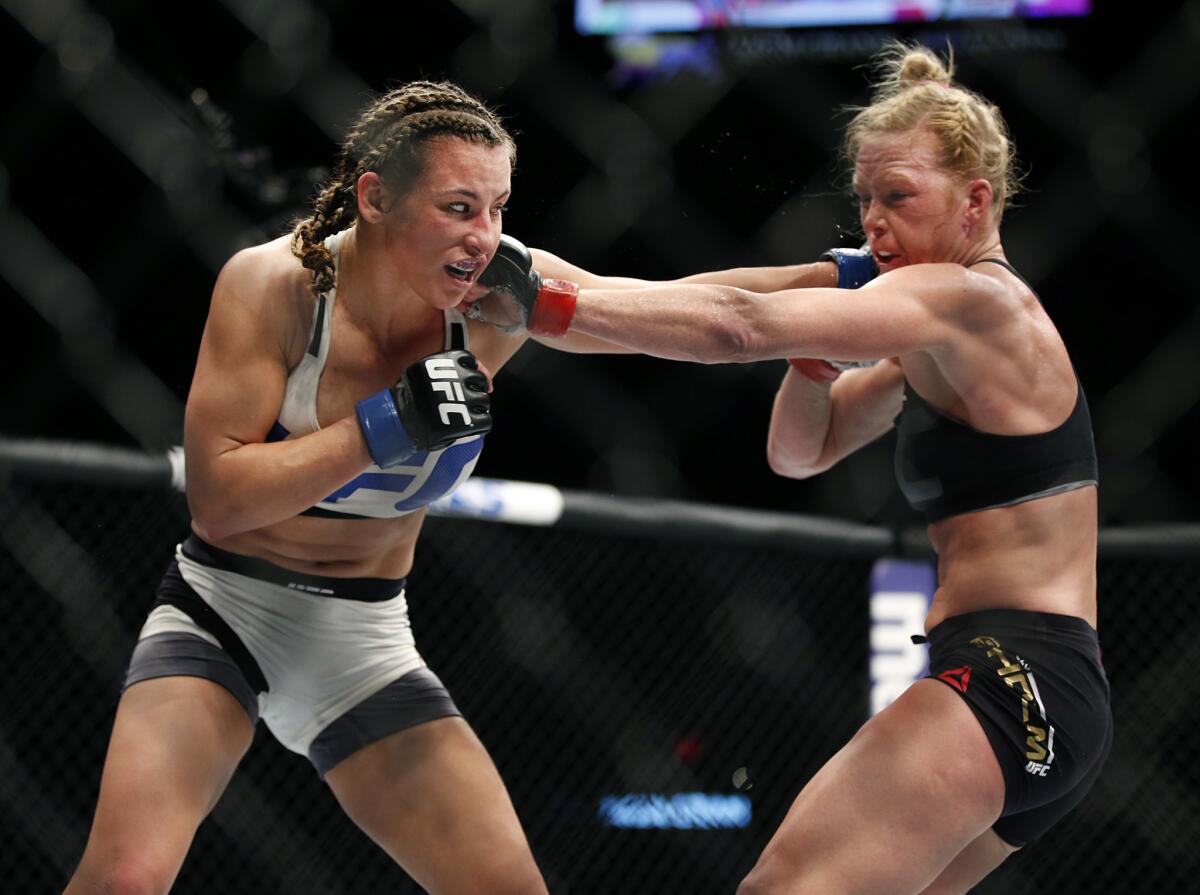Miesha Tate, left, trades punches with Holly Holm during UFC 196 on March 5.