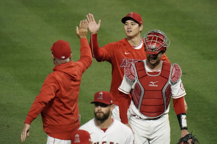 The Angels' Shohei Ohtani, top, gives manager Joe Maddon a high-five while celebrating a 9-2 win against the Dodgers.