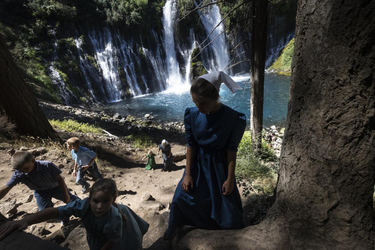 Children clamber up a dirt path from majestic Burney Falls. 