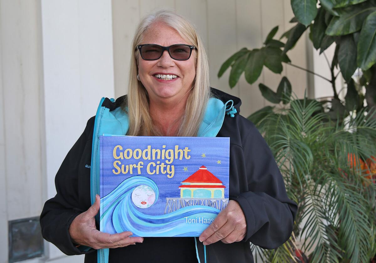 Huntington Beach author Toni Haas shows the cover of her children's book, "Goodnight Surf City."