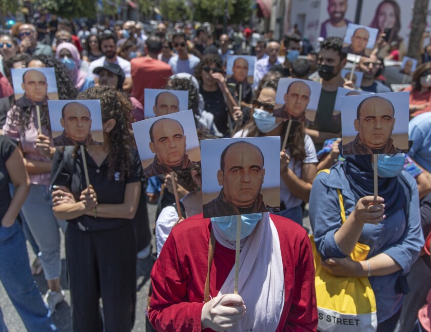 Demonstrators in Ramallah carry pictures of Nizar Banat at a rally protesting his death while in police custody.