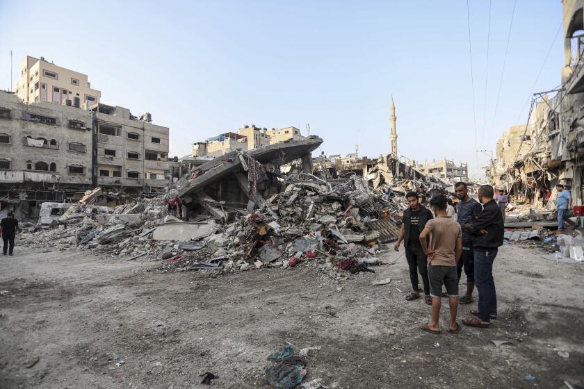 Palestinians inspect the damage of destroyed buildings caused by the ongoing Israeli airstrikes on Gaza City, Saturday, Oct. 28, 2023. (AP Photo/Abed Khaled)