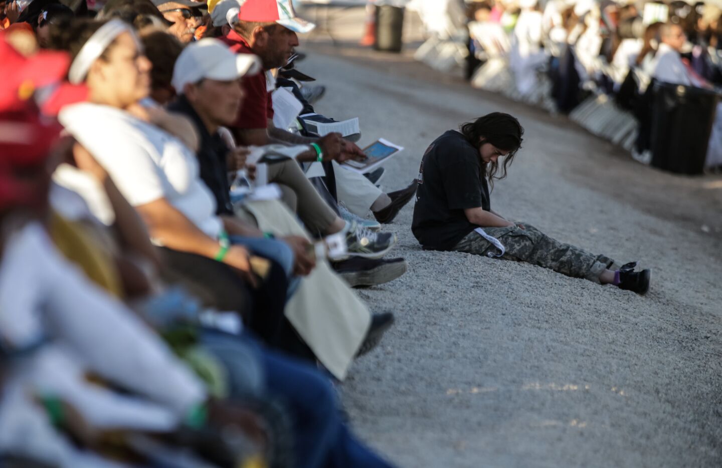 People pray quietly on the U.S. side of the border with Mexico on Wednesday as Pope Francis says a prayer during the final day of his trip to Mexico.