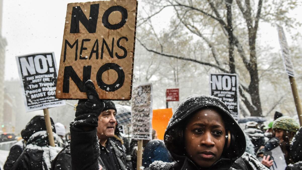 People carry signs at a New York protest against sexual harassment on Dec. 9.