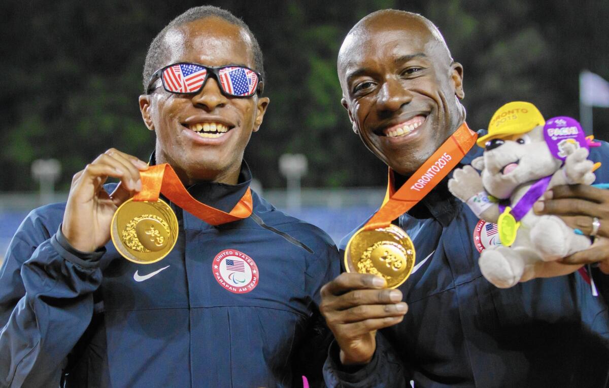 David Brown, left, and his guide, Jerome Avery, show off their gold medals during the 2015 Parapan Am Games in Toronto, Canada