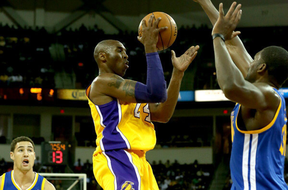 Lakers guard Kobe Bryant looks to pass after driving against the Warriors in a preseason game last month.