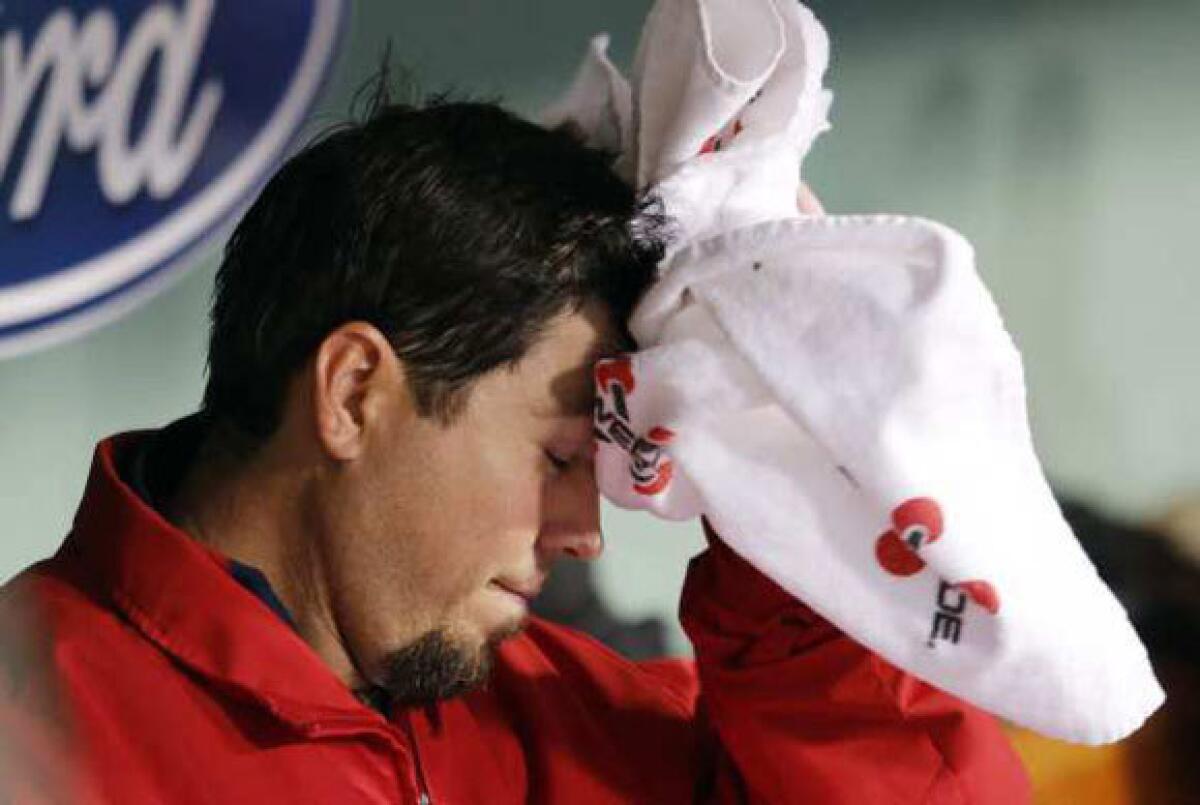 Josh Beckett wipes his head in the dugout after being taken out in the third inning.