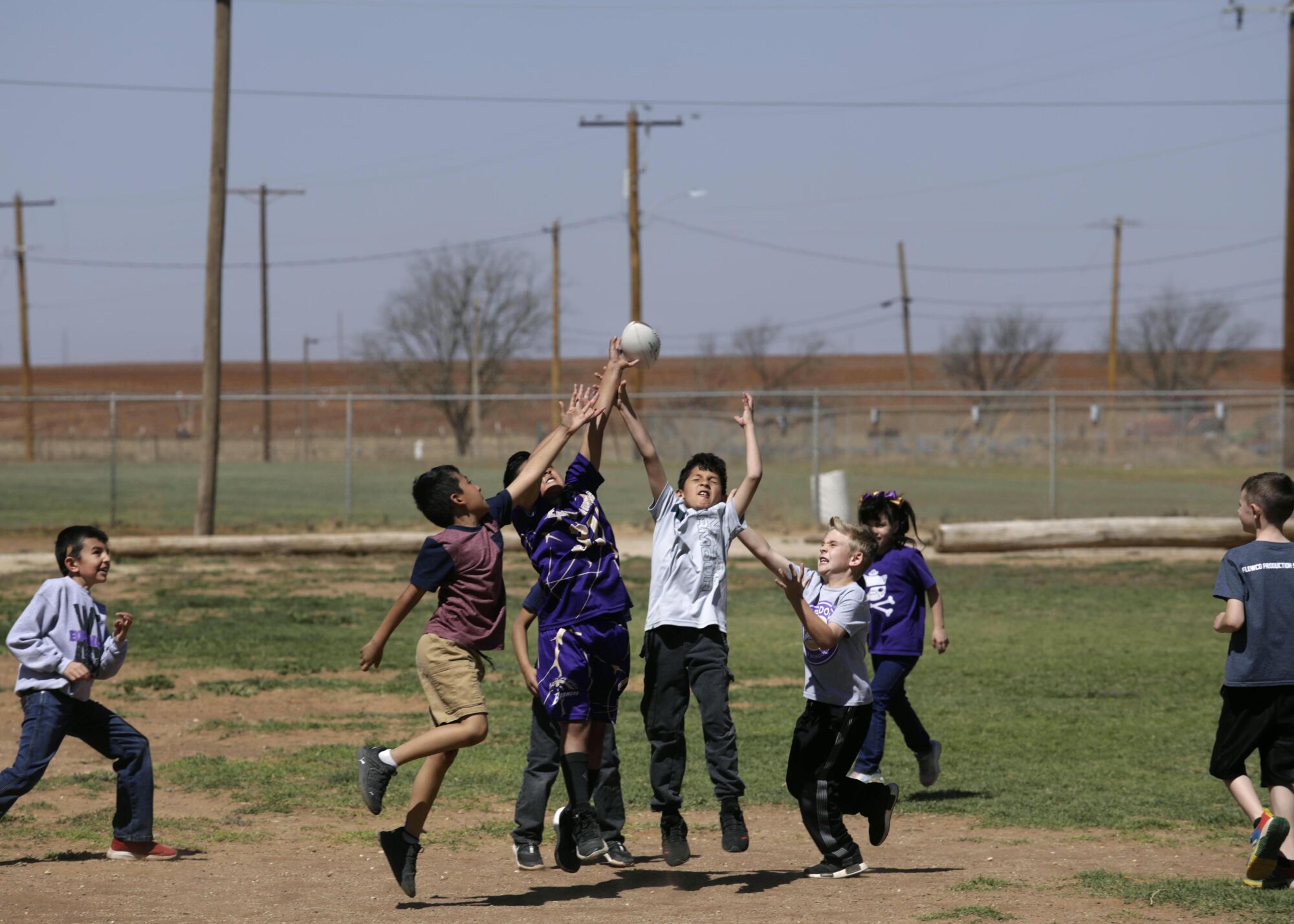 Meadow students play football during lunch.