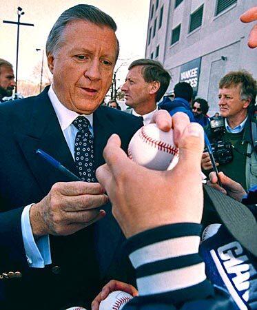 Steinbrenner, making his return to baseball after a two-year ban, autographs baseballs for waiting fans as he heads into Yankee Stadium for the season opener against the Kansas City Royals in 1993. See full story