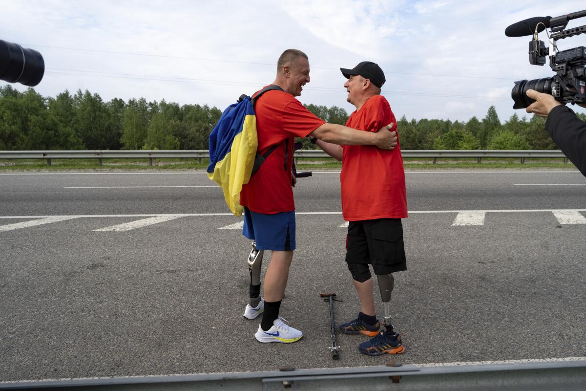 Ukrainian war veterans from 2014 hug each other.