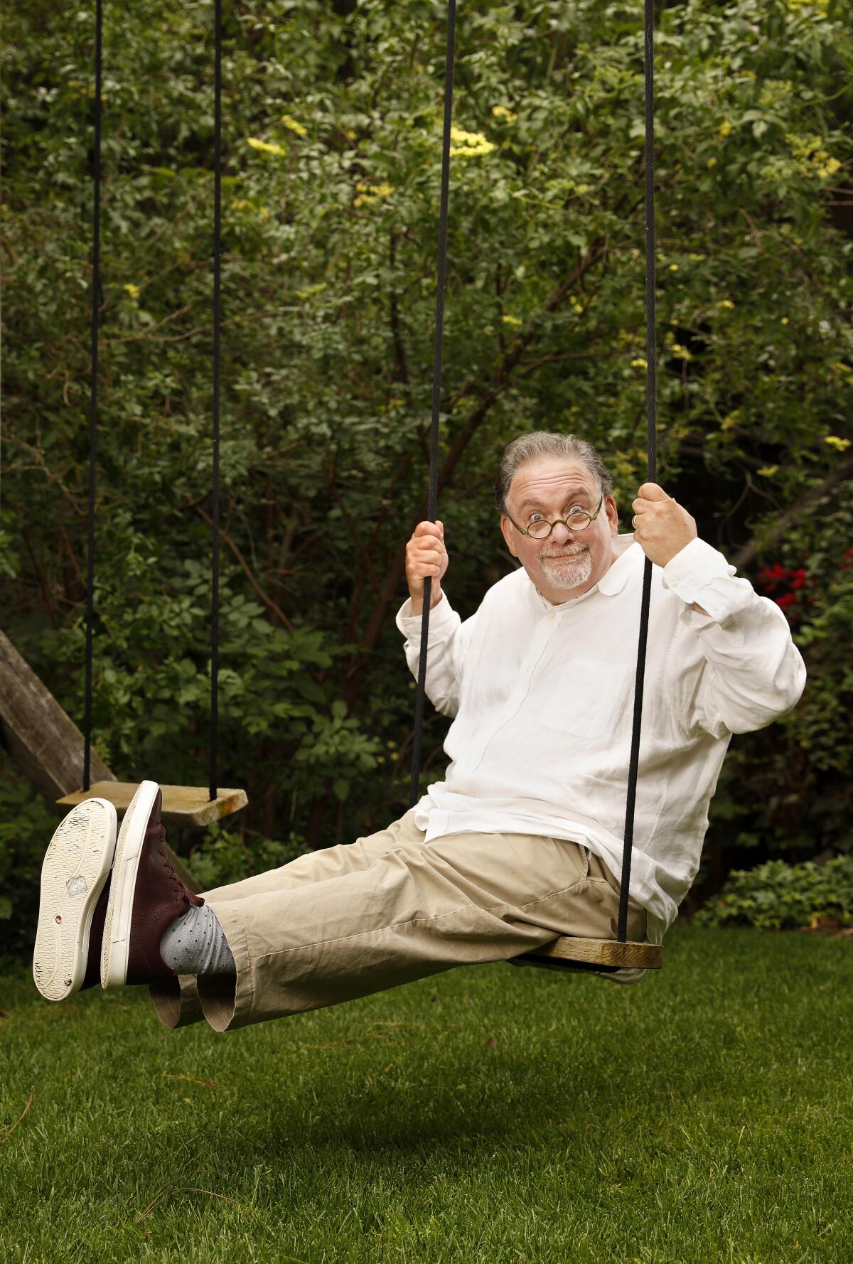 Showrunner Bruce Miller, "The Handmaid's Tale," sticks his legs out straight on a backyard swing.