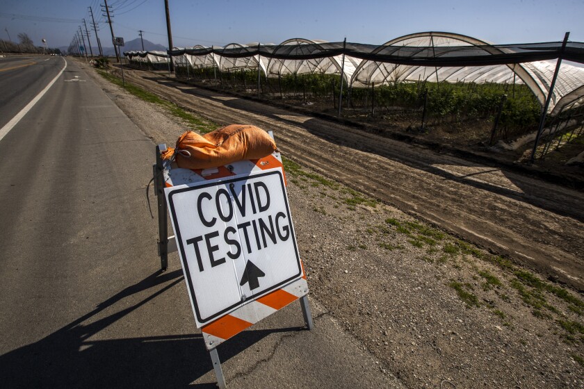 A COVID-19 testing sign sits beside a field in Oxnard.