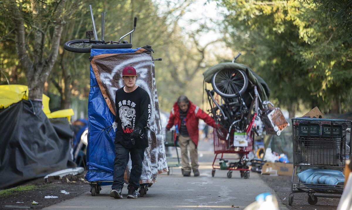 Homeless campers along the Joe Rodota Trail use shopping carts  and improvised dollies to move their belongings in Santa Rosa.